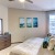 Bedroom with carpet, comfortable bed, and warm lighting