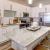 Kitchen area with large island with barstools and pendant lights
