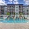 Pool with lounge chairs surrounded by apartment building