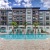 Pool with lounge chairs surrounded by apartment building