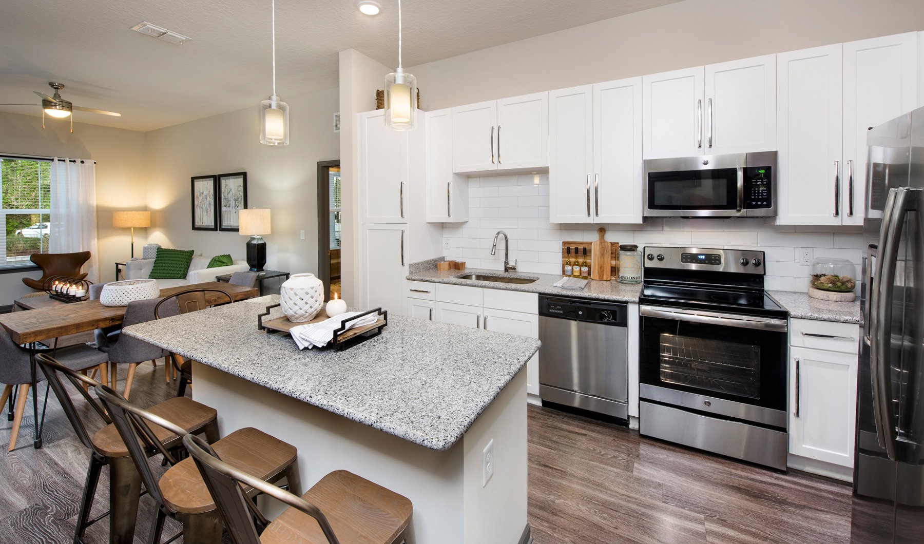 Kitchen with white cabinets, quartz countertops, and pendant lights