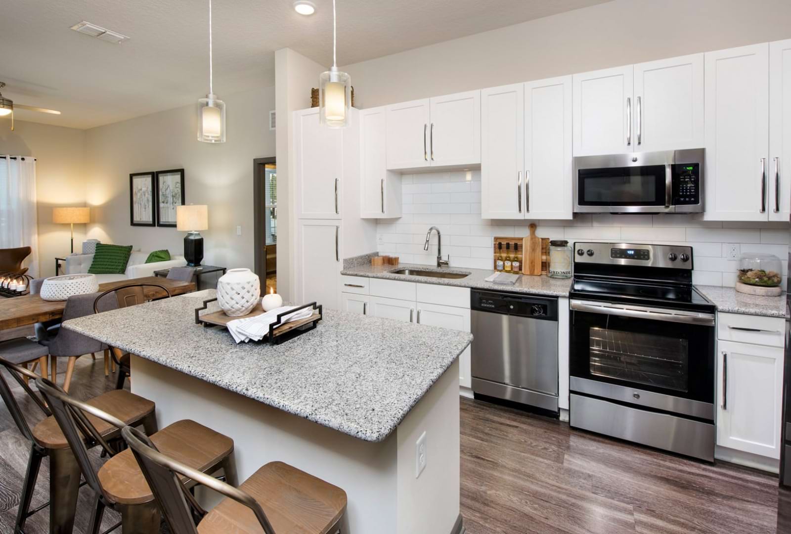 Kitchen with white cabinets, quartz countertops, and pendant lights